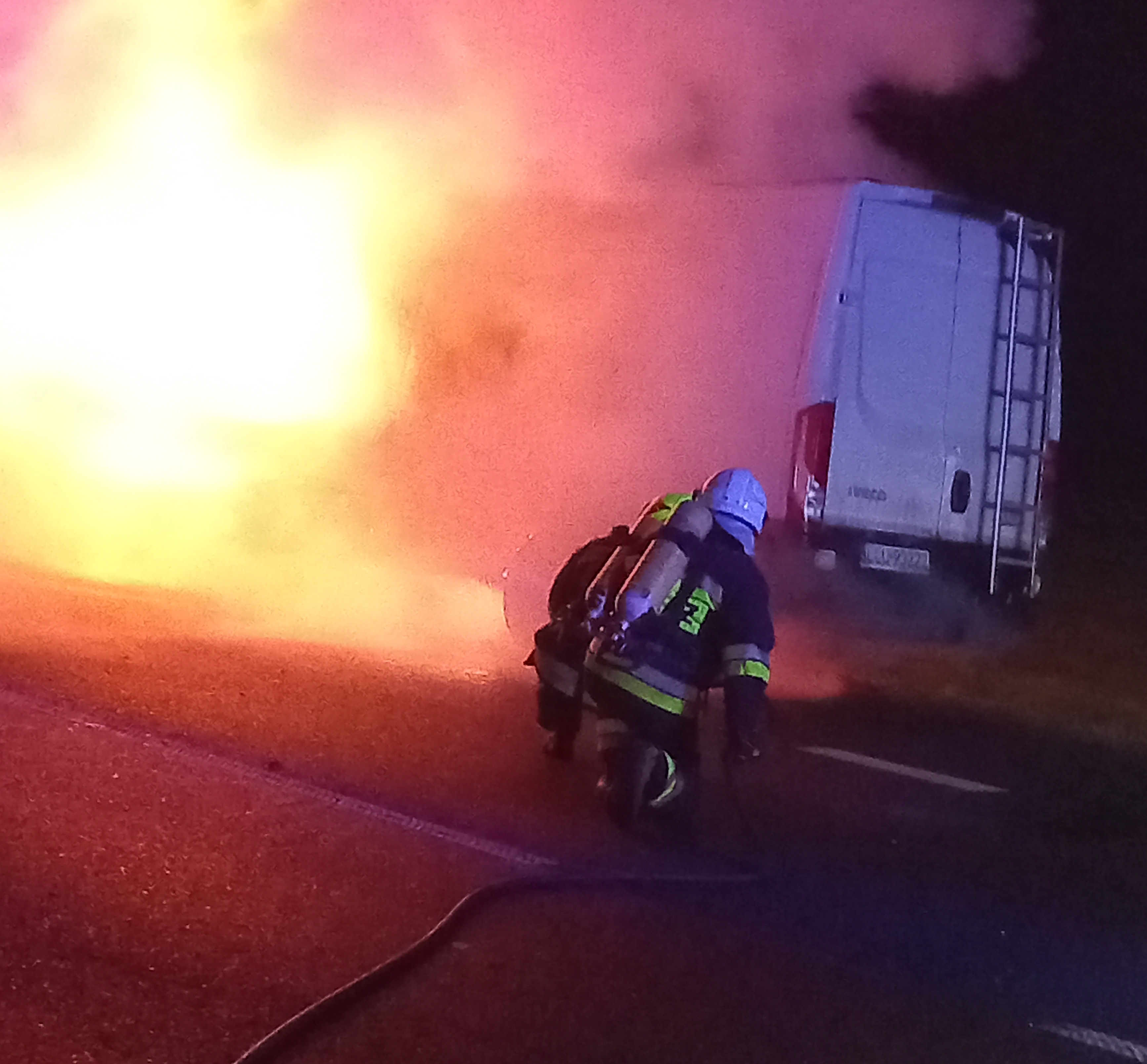 Pożar samochodu dostawczego. Strażacy gaszą płonący samochód.