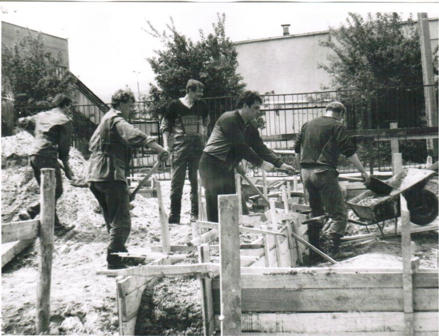 Na zdjęciu plac budowy budynku KP PSP w Myślenicach. Na środku 5 pracowników ubranych w ubrania robocze, podczas prac budowlanych.
