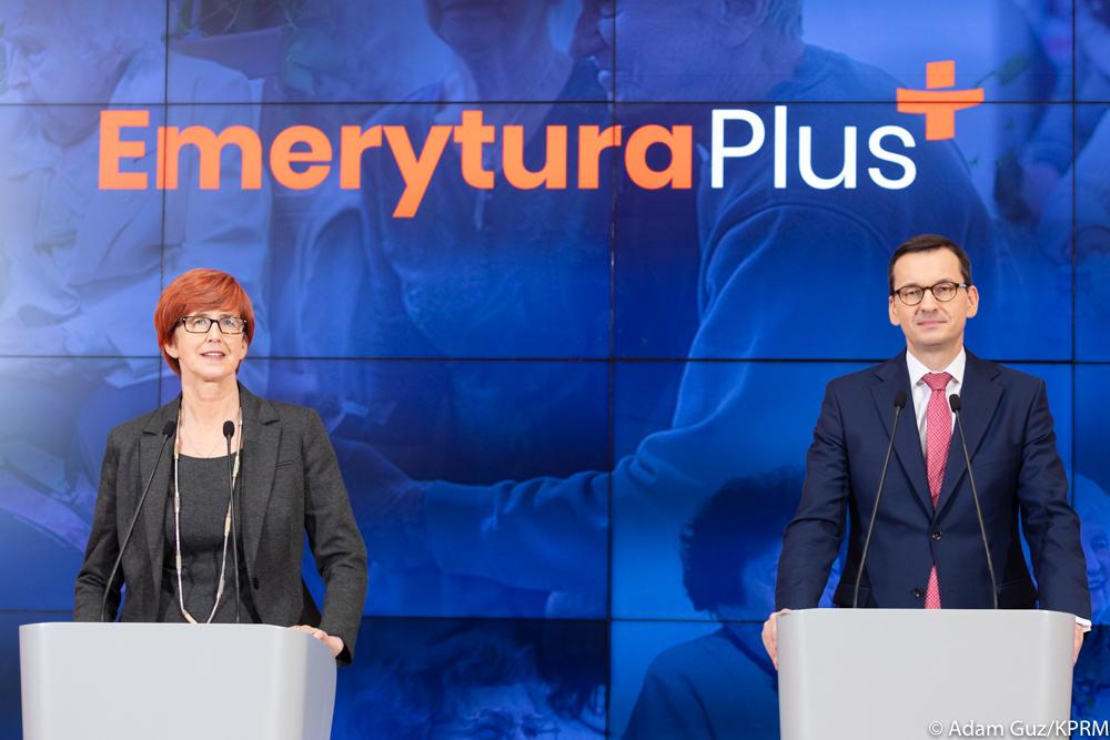 Minister Elżbieta Rafalska (po lewej) i premier Mateusz Morawiecki stoją przy mównicach na tle ściany wizyjnej, na której widnieje napis Emerytura Plus.