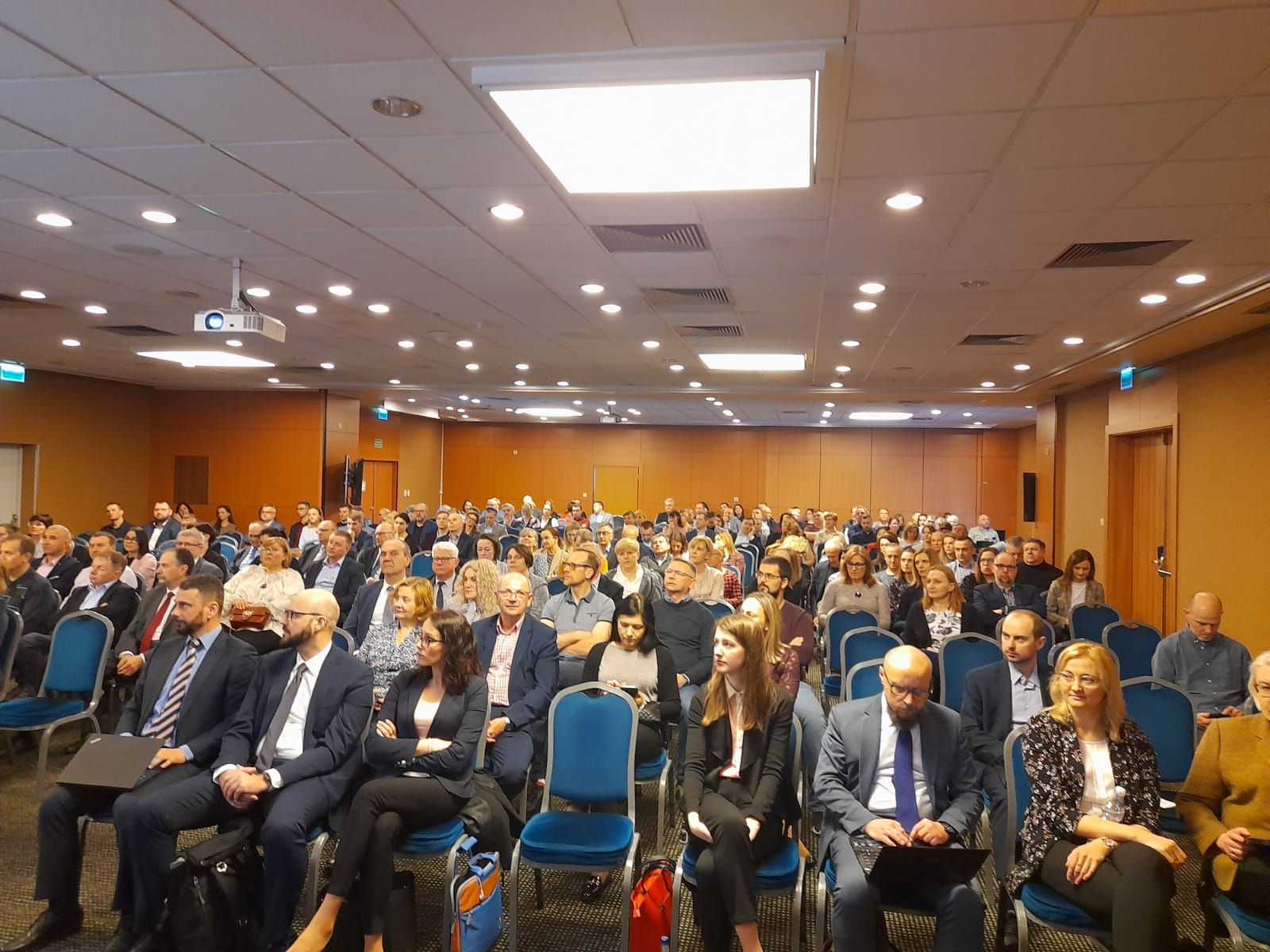 Zdjęcie przedstawia uczestników spotkania Służby Geodezyjnej i Kartograficznej w sali konferencyjnej.