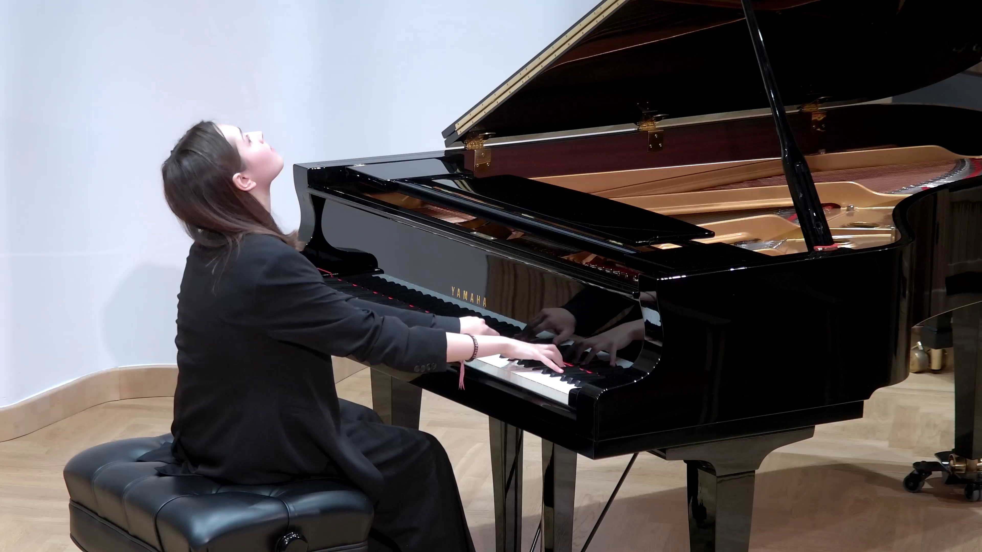 Zdjęcie. Na estradzie Sali Koncertowej PSM I i II stopnia w Nysie na czarnym fortepianie gra młoda pianistka - Veronika Zalevska.