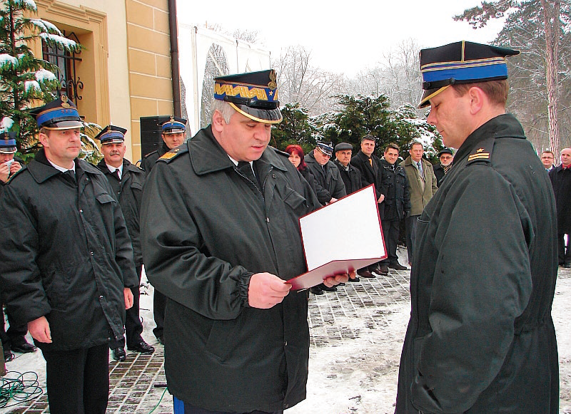 Zdjęcie przedstawia moment przekazania dokumentów przekazania samochodu pożarniczego podczas odprawy rocznej KW PSP.