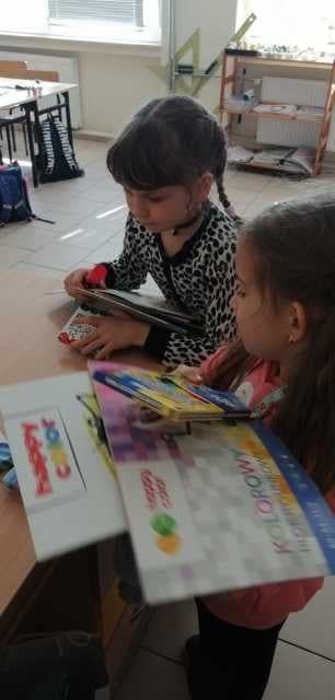 Zdjęcie przedstawiające wwie ukraińskie dziewczynki korzystające z podarowanych przybowów szkolnych 