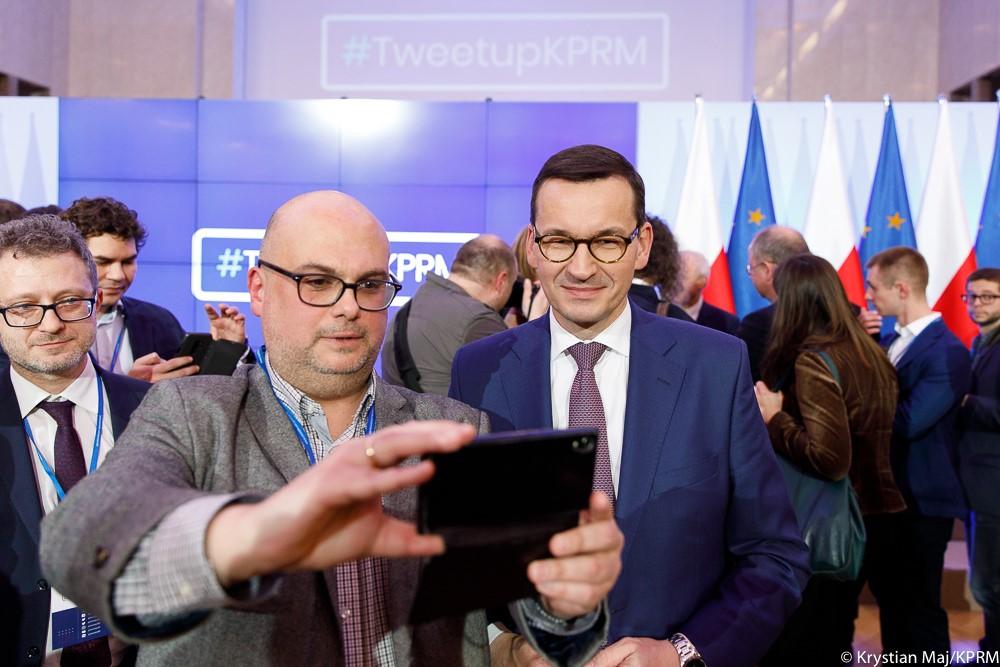 Premier Mateusz Morawiecki podczas robienia selfie z uczestnikiem Tweetupa.