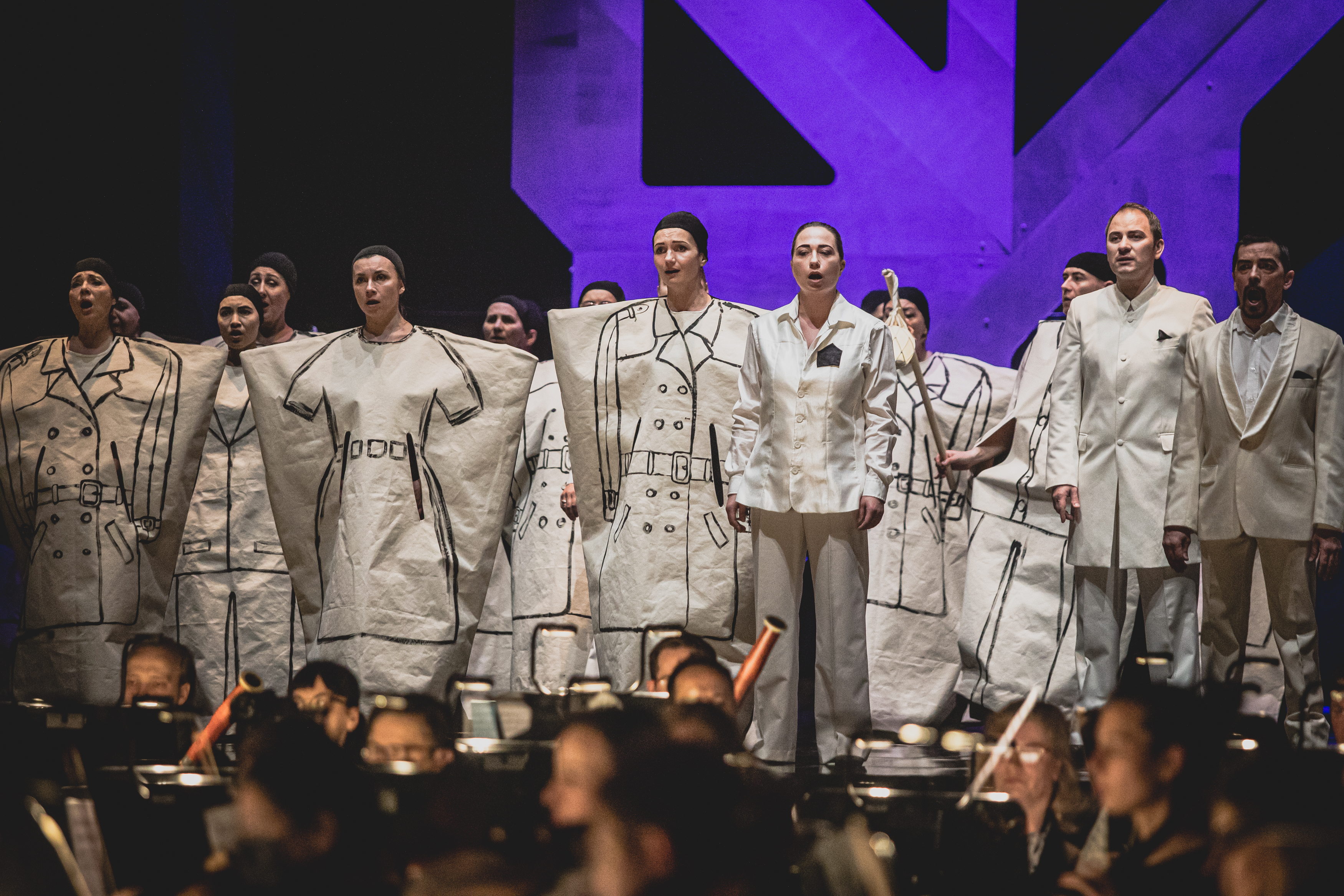 Występ chóru - śpiewacy w przebraniach na scenie, poniżej orkiestra