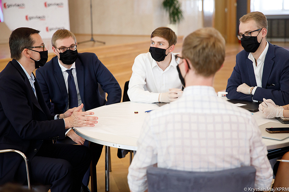 Premier Mateusz Morawiecki i minister Jan Sarnowski dyskutują podczas spotkania z młodzieżą