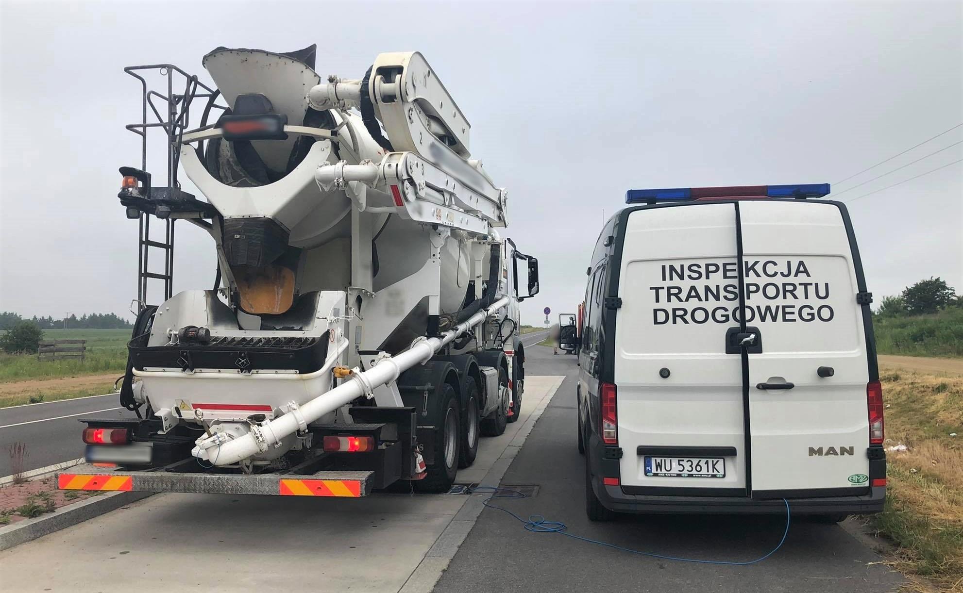 Betoniarka na wagach ITD i stojący koło niej radiowóz.