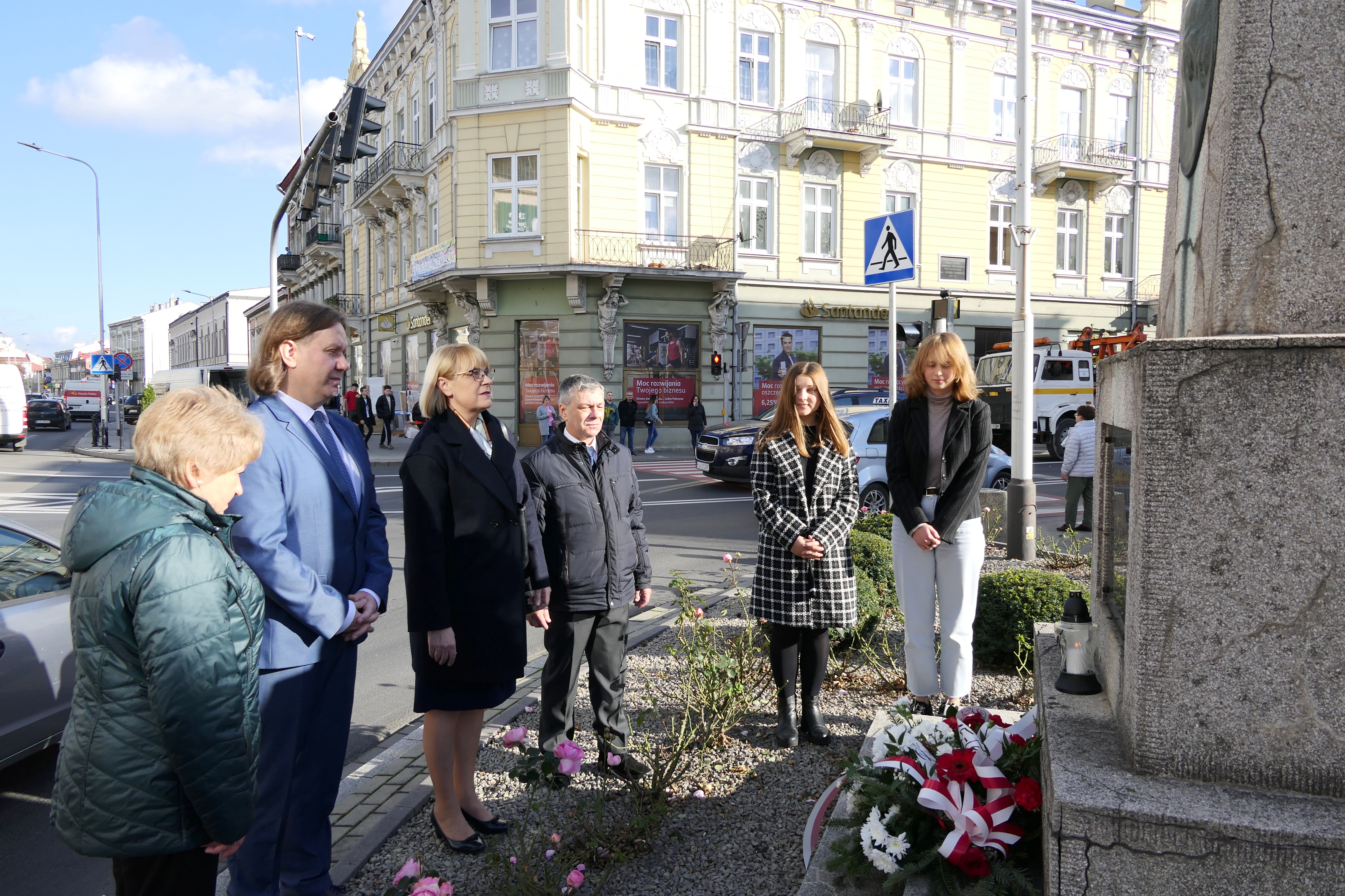 Zdjęcie złożenia kwiatów przy pomniku F. Chopina stojącego przy zbiegu ul. Jana Pawła II i J. Słowackiego - rozpoczęcie uroczystych Obchodów Jubileuszu 75-lecia Szkoły Muzycznej I stopnia im. Fryderyka Chopina w Jarosławiu. Na tle skrzyżowania ulic kolejno od lewej strony: nauczyciel mgr Maria Zwolińska, wicedyrektor ZPSM Piotr Polański, dyrektor ZPSM Grażyna Sereda, nauczyciel mgr Andrzej Grębosz oraz dwie uczennice PSM I st. im. F. Chopina w Jarosławiu