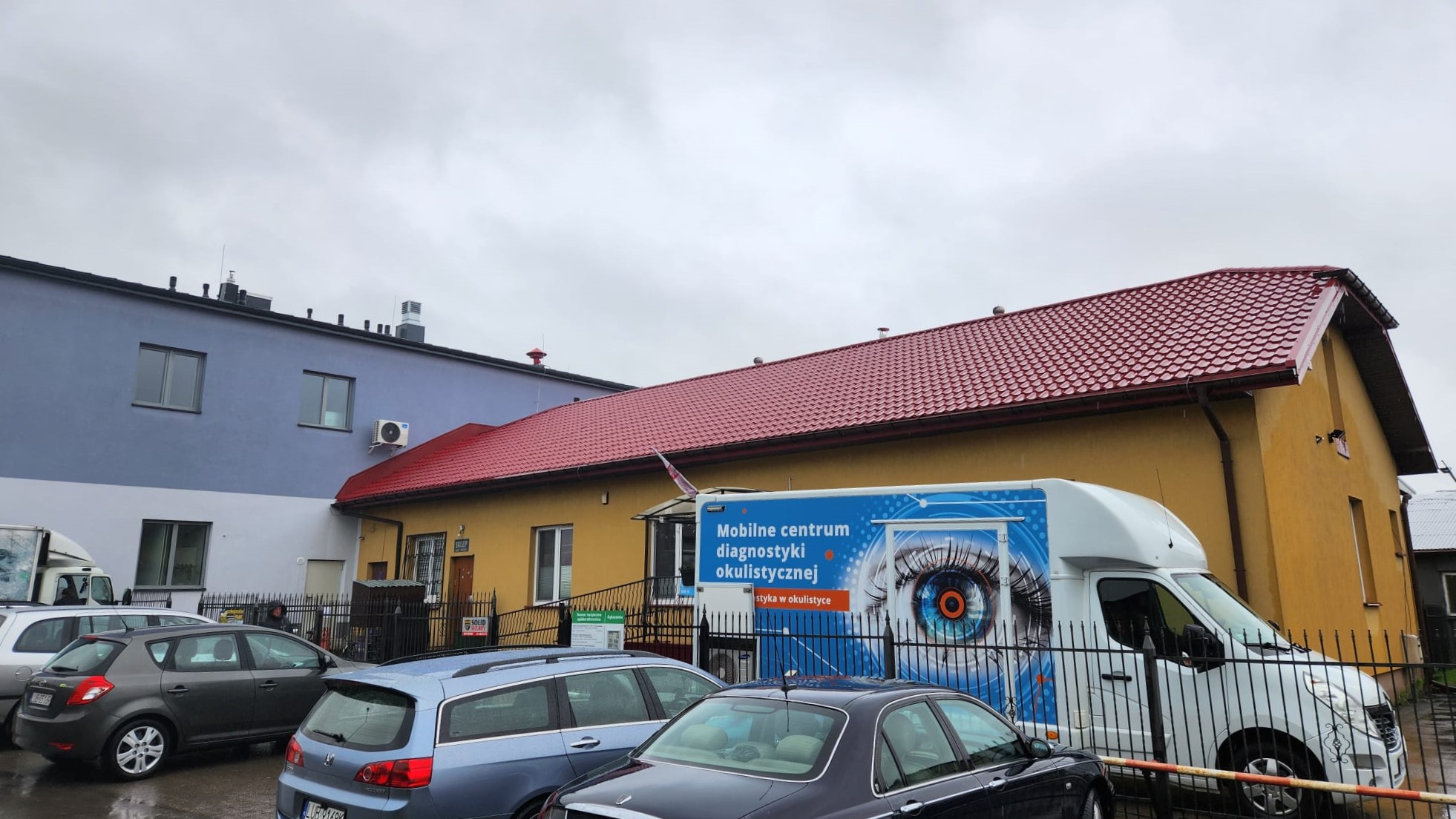 Samochód diagnostyczny Okobus zaparkowany przed przychodnią lekarską w Mętowie.