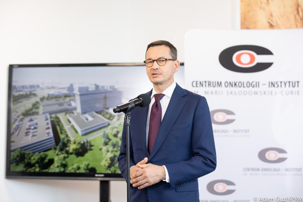 Premier Mateusz Morawiecki stoi podczas przemówienia.