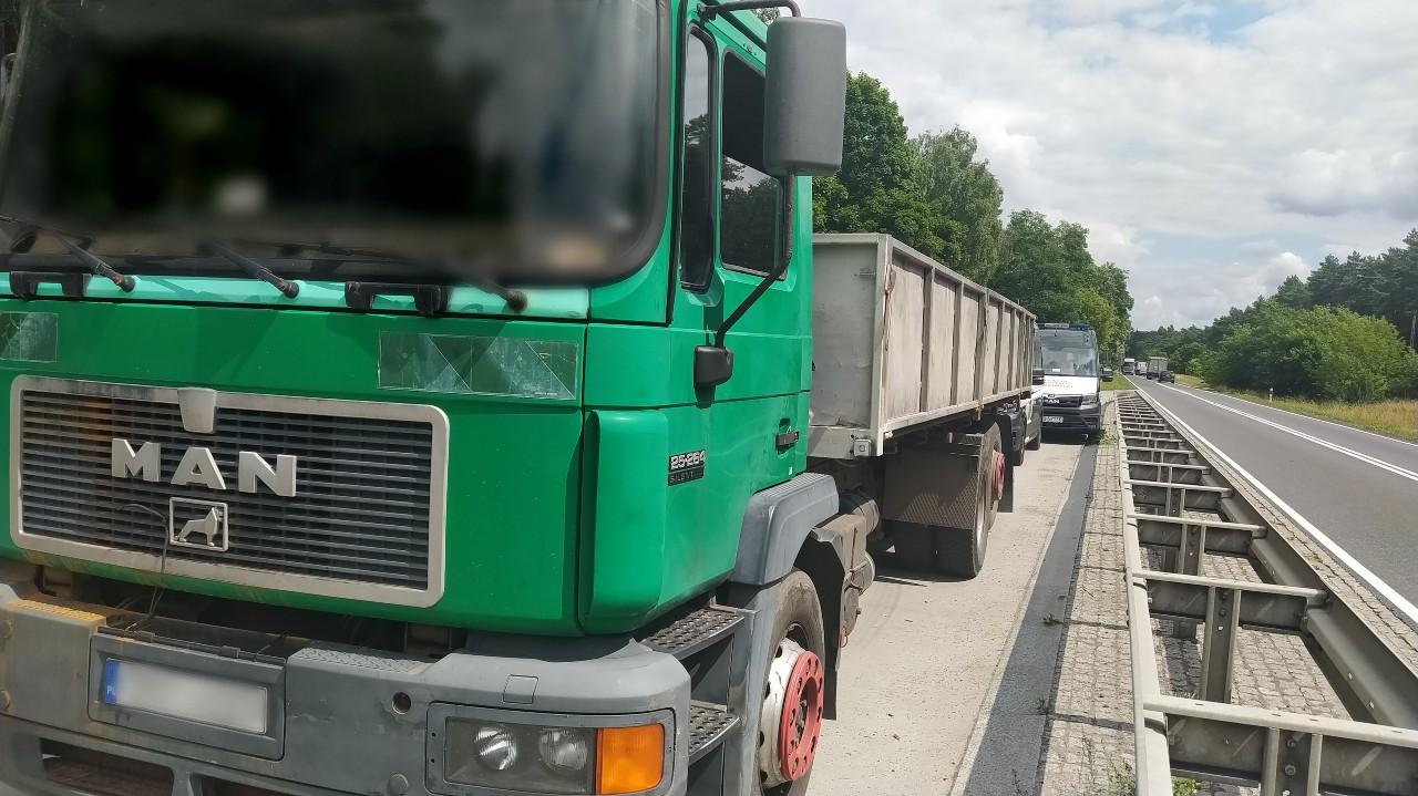 Widoczny przód i lewy bok kontrolowanej ciężarówki. Z tyłu stoi oznakowany radiowóz ITD.