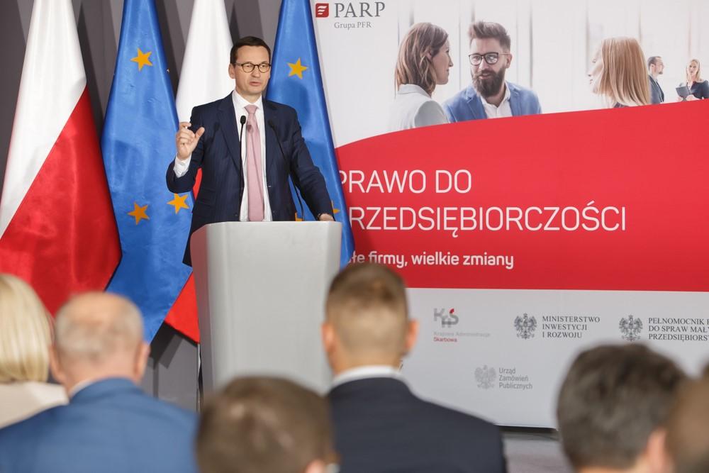 Premier Mateusz Morawiecki przy mównicy podczas konferencji.
