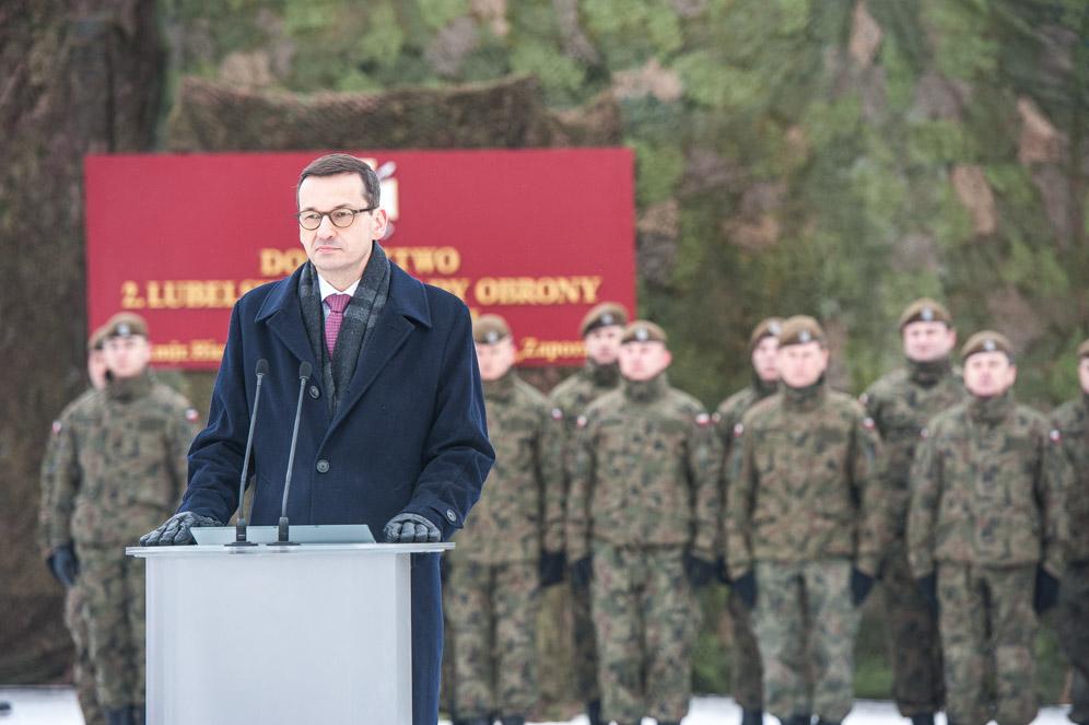 Premier Mateusz Morawiecki przy mównicy, a w tle żołnierze.