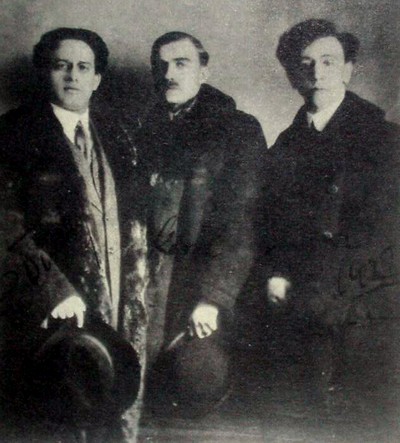 Czarno-białe zdjęcie z 1912 roku w Wiedniu. Od lewej: Grzegorz Fitelberg, Karol Szymanowski, Artur Rubinstein. Ubiór sugeruje porę jesienno-zimową (płaszcze, kapelusze trzymane w dłoniach). 