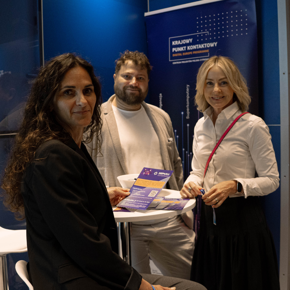Reprezentanci CPPC przy stoisku podczas wydarzenia. Od lewej: Izabela Sobczak Naczelniczka Wydziału Realizacji Projektów 2, Adrian Gazarkiewicz reprezentant Krajowego Punktu Kontaktowego Programu Cyfrowa Europa i Aneta Marchewka-Kuliś Dyrektorka Departamentu Strategii.