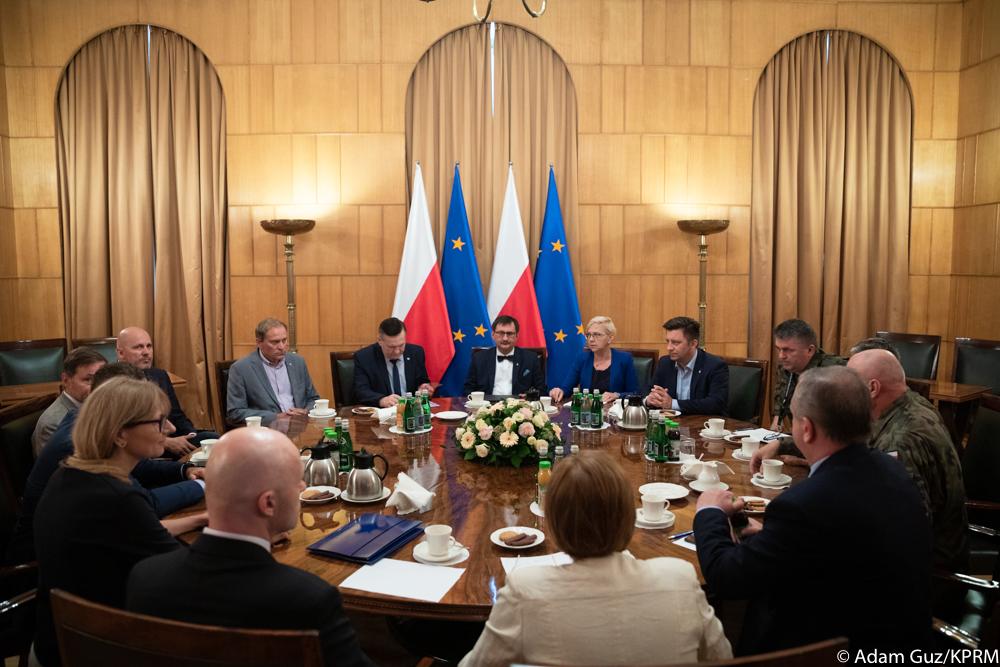 Sztab kryzysowy przy stole.