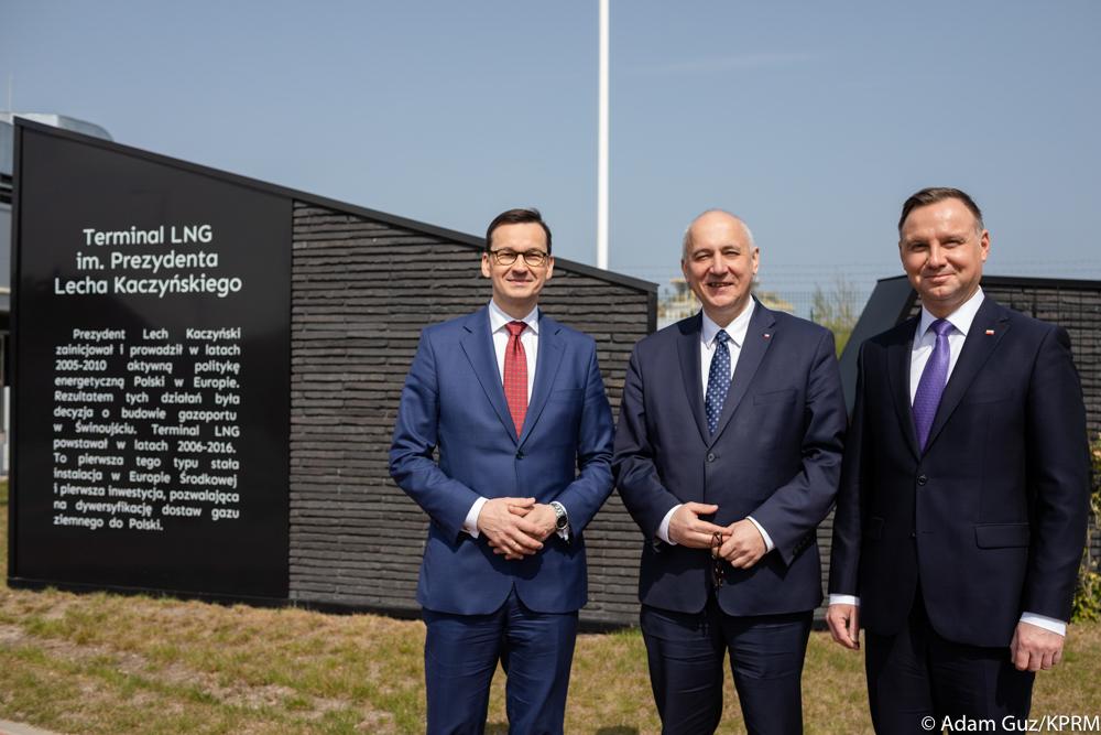 Od lewej: premier Mateusz Morawiecki, minister Joachim Brudziński i prezydent Andrzej Duda na tle napisu "Terminal LNG im. Lecha Kaczyńskiego". 