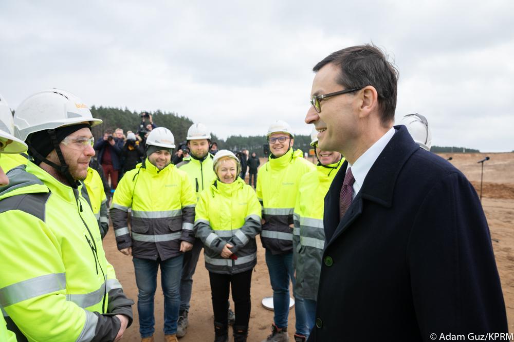 Premier Mateusz Morawiecki rozmawia z pracownikami budowy.