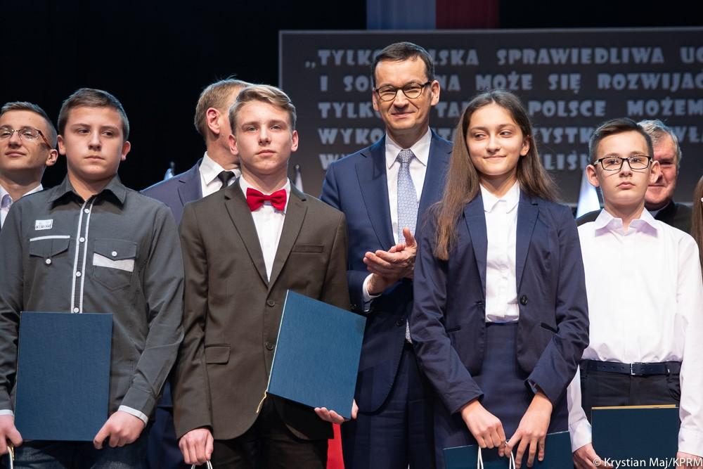 Premier Mateusz Morawiecki razem z uczniami, którzy otrzymali stypendia.