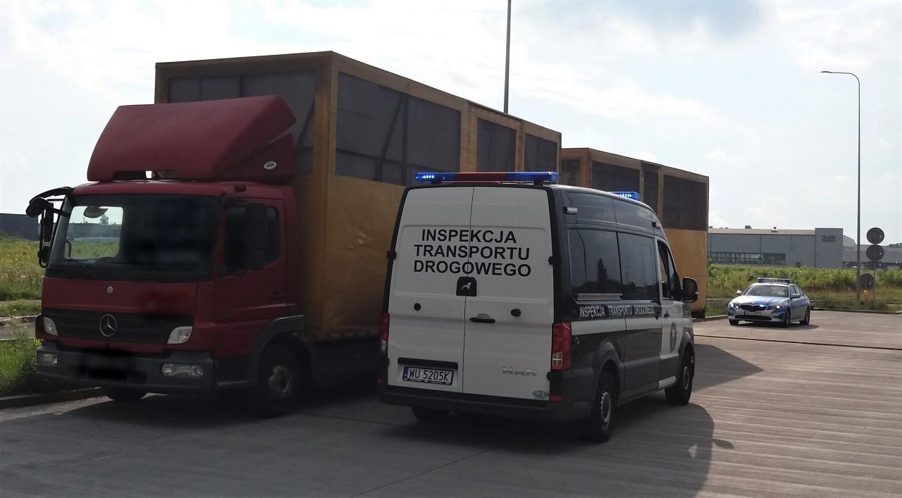 Oznakowany furgon ITD i stojący obok zespół pojazdów.