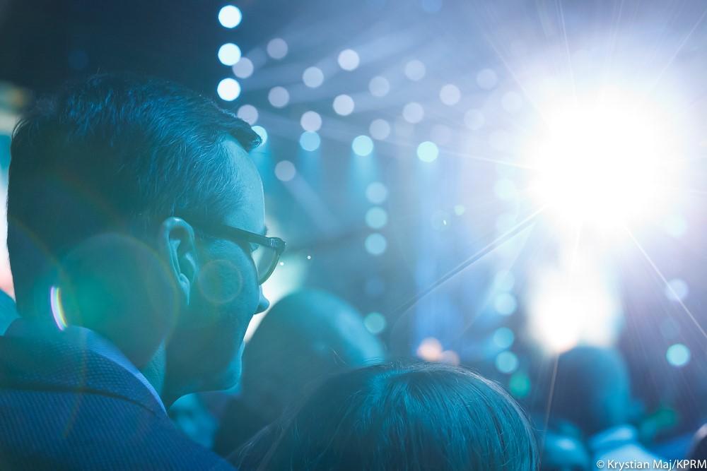 Premier Mateusz Morawiecki podczas koncertu spogląda na scenę.