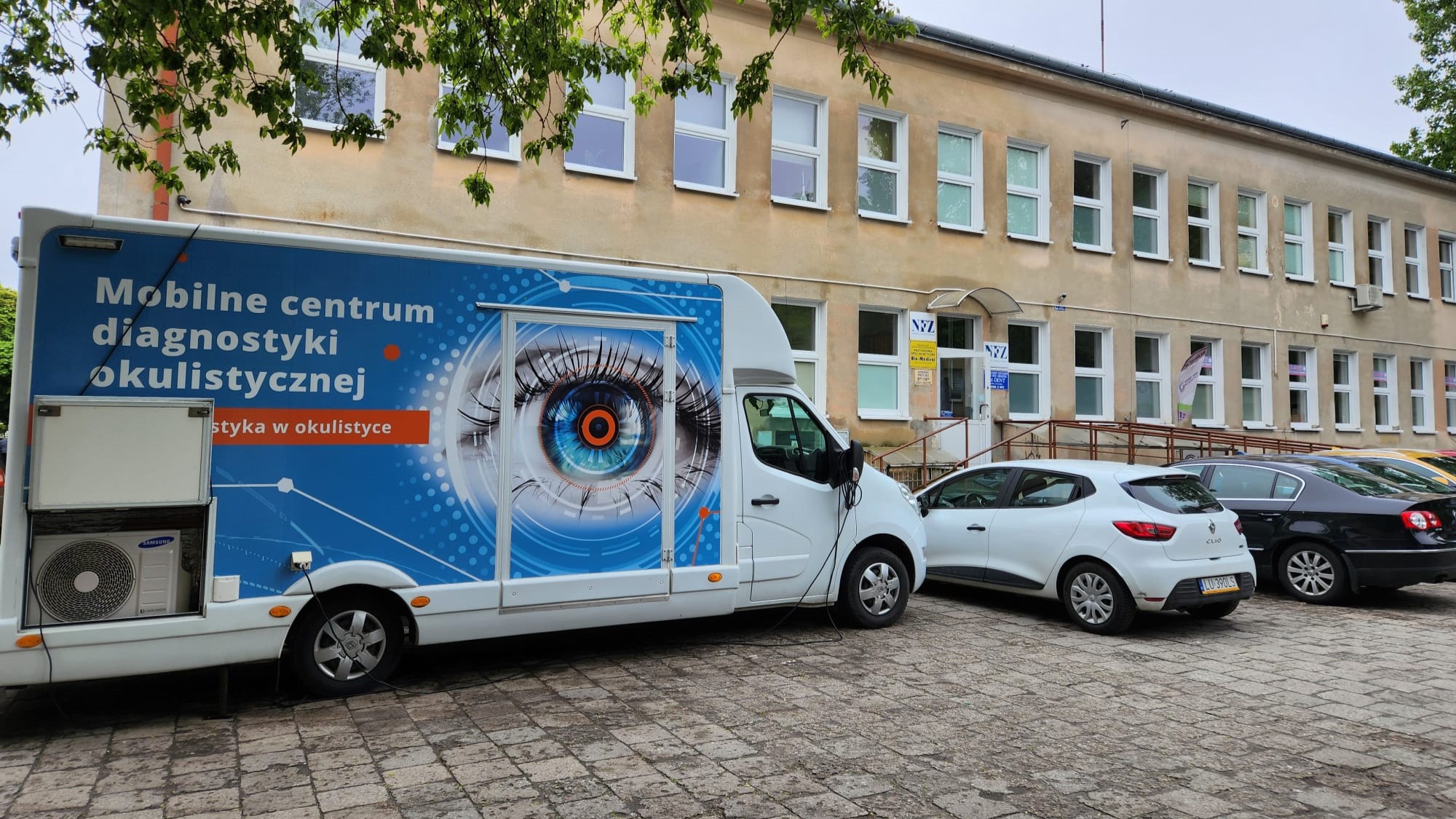 Samochód diagnostyczny Okobus zaparkowany przed przychodnią lekarską w Lublinie.