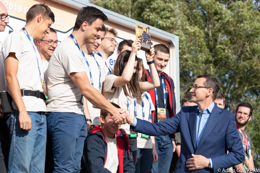 Premier Mateusz Morawiecki wręcza medale zwycięskiemu zespołowi.