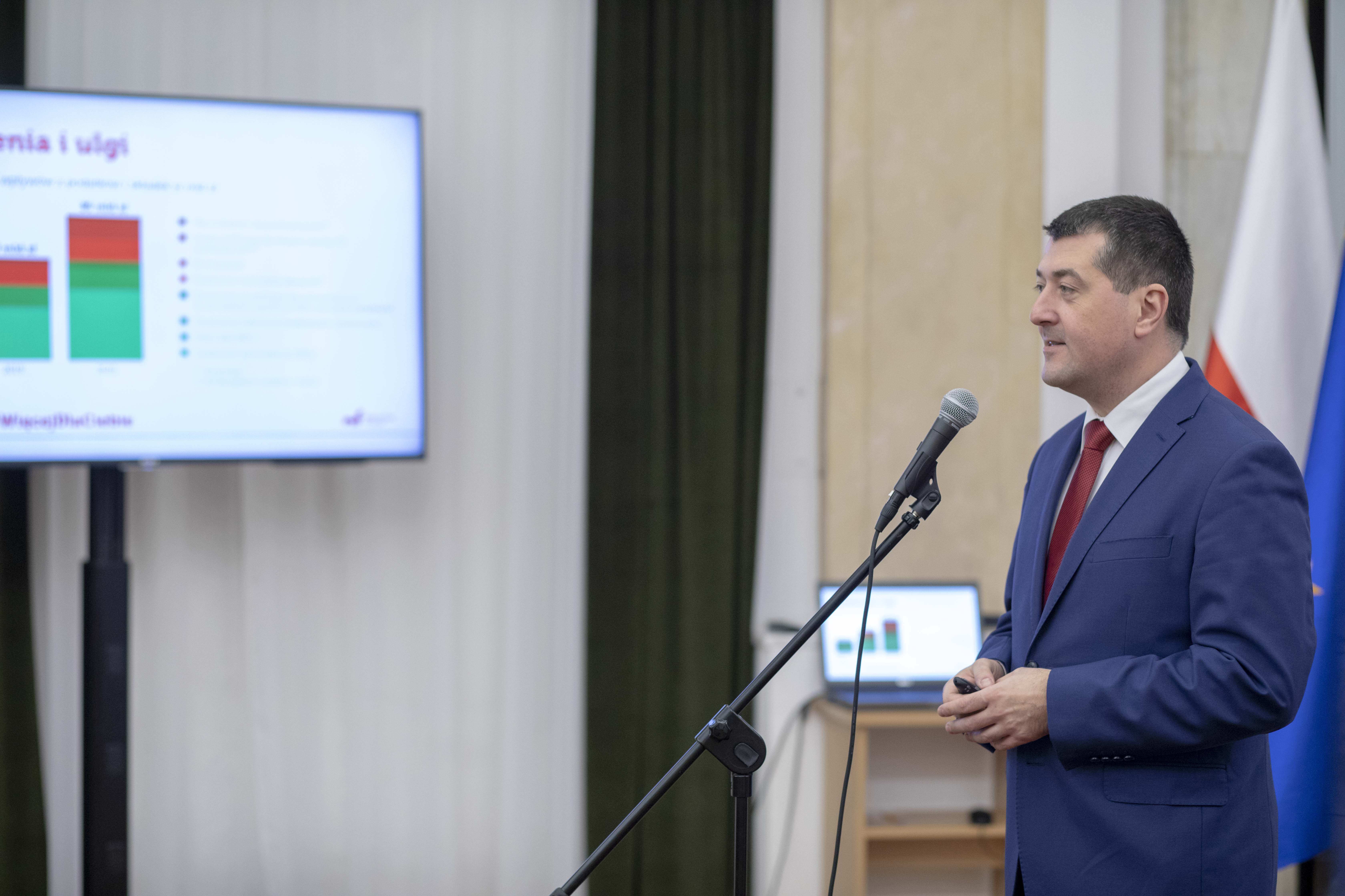 Uśmiechnięty wiceminister Leszek Skiba przemawia podczas konferencji