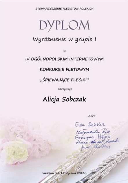 Dyplom ma jasnoróżowe tło. W jego środkowej części znajdują się informacje dotyczące konkursu. Poniżej znajdują się odręczne podpisy członków jury. W dolnej części dyplomu. w tle, umieszczone zostały fotografie kwiatów oraz dwóch fletów.