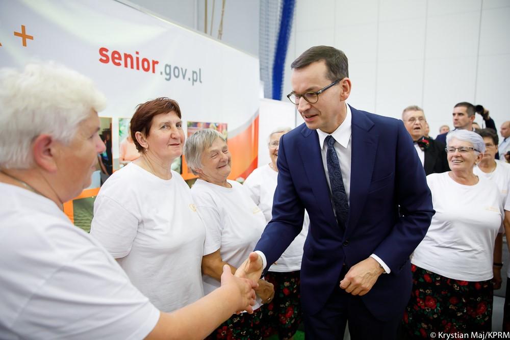 Premier Mateusz Morawiecki wita się z seniorami.