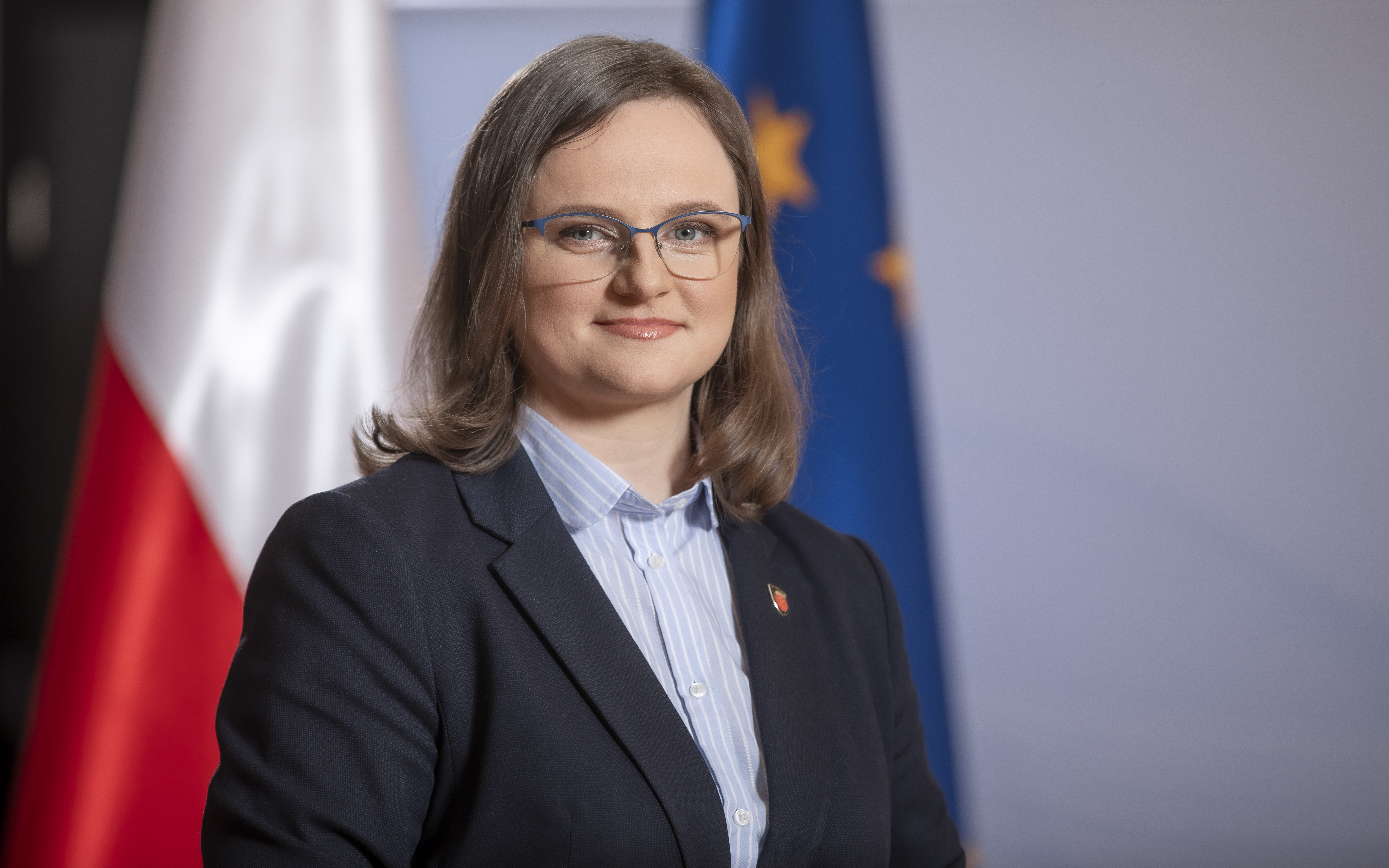 Anna Chałupa Podsekretarz Stanu, Zastępca Szefa Krajowej Administracji Skarbowej na tle flagi Polski i Unii Europejskiej