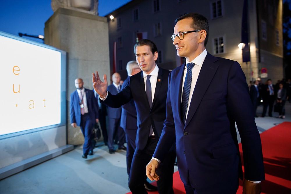 Premier Mateusz Morawiecki z kanclerzem Austrii Sebastianem Kurzem idą po czerwonym dywanie.
