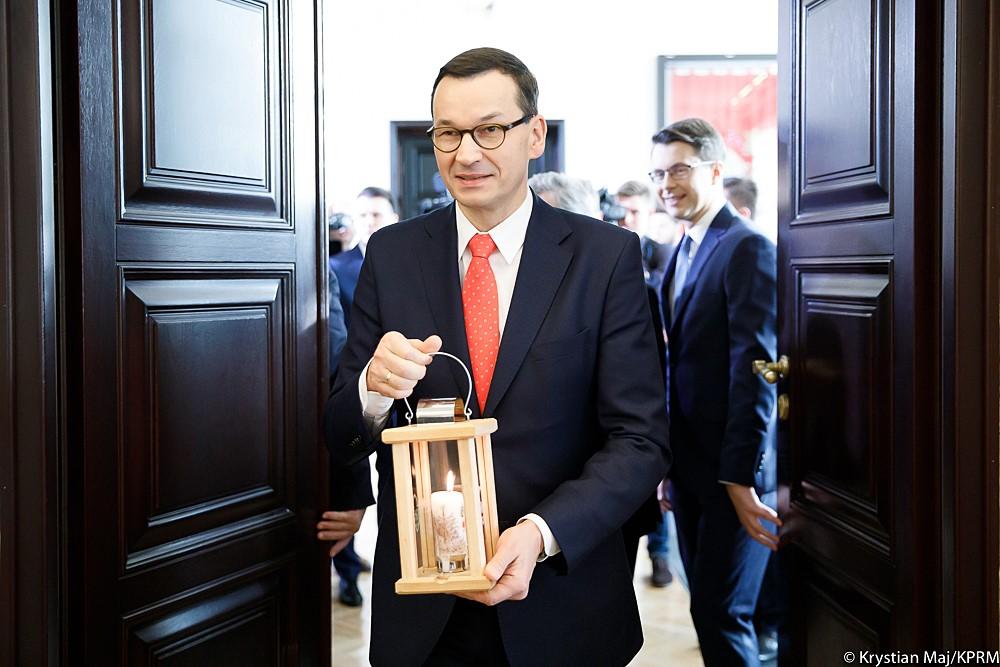 Premier idzie i niesie lampion z Betlejemskim Światłem Pokoju.