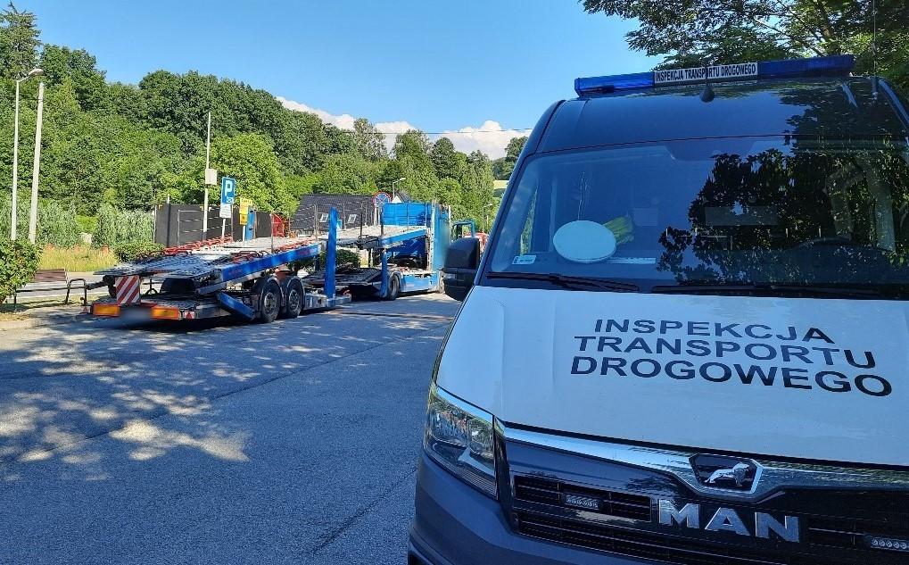 Przód radiowozu ITD i stojący w oddali samochód ciężarowy.