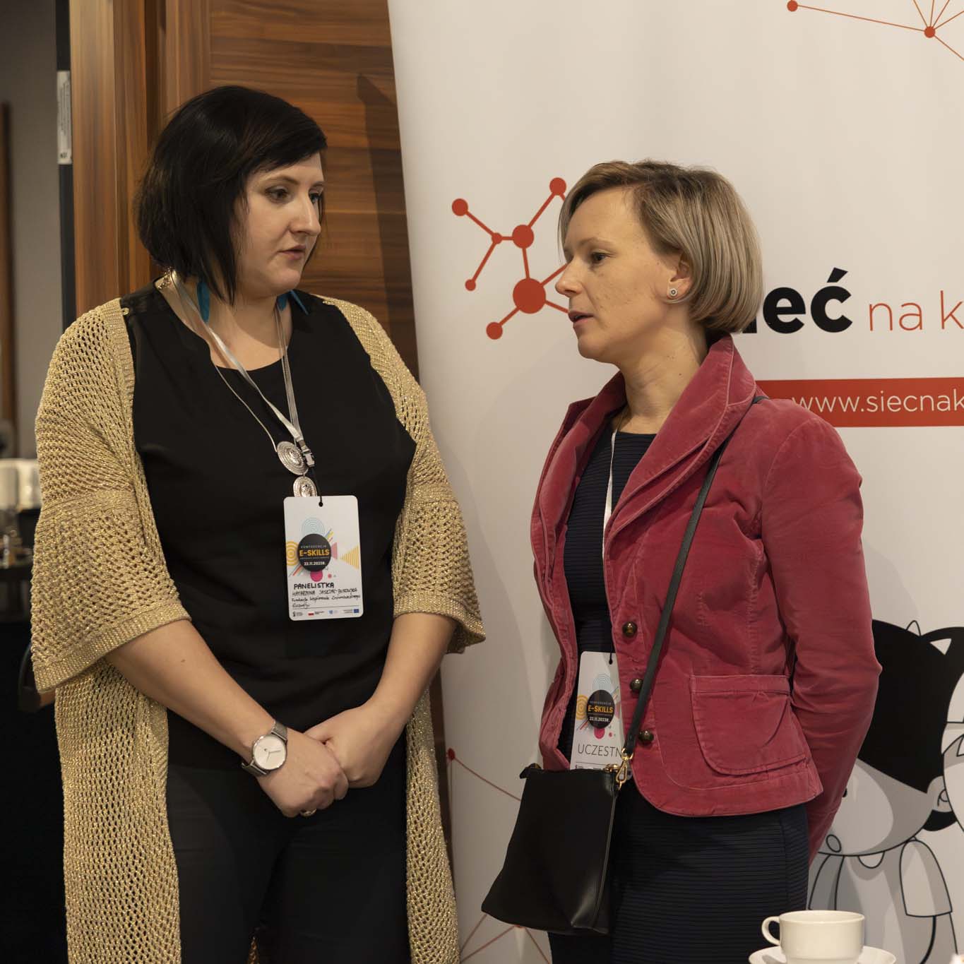 Dwie kobiety stoją i rozmawiają.