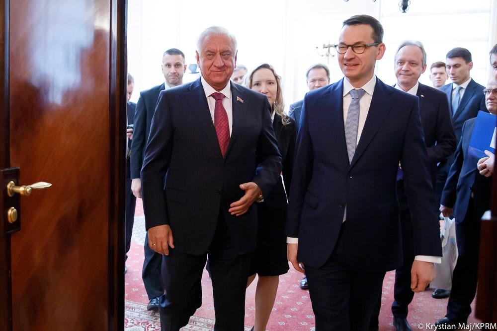 Premier Mateusz Morawiecki oraz Michaił Miasnikowicz wchodzą do pomieszczenia, a za nimi idą współpracownicy.