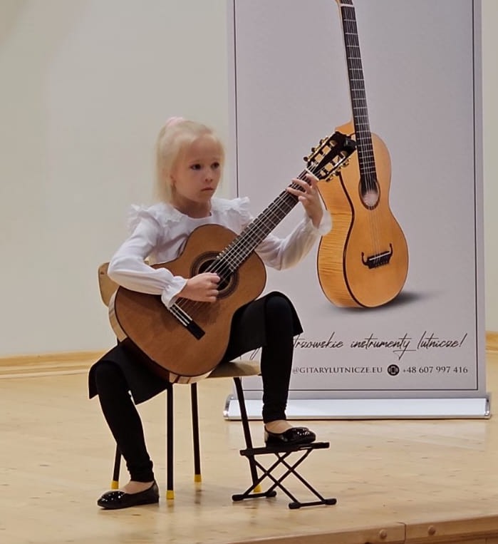 Uczennica Zuzanna Stach na scenie z gitarą