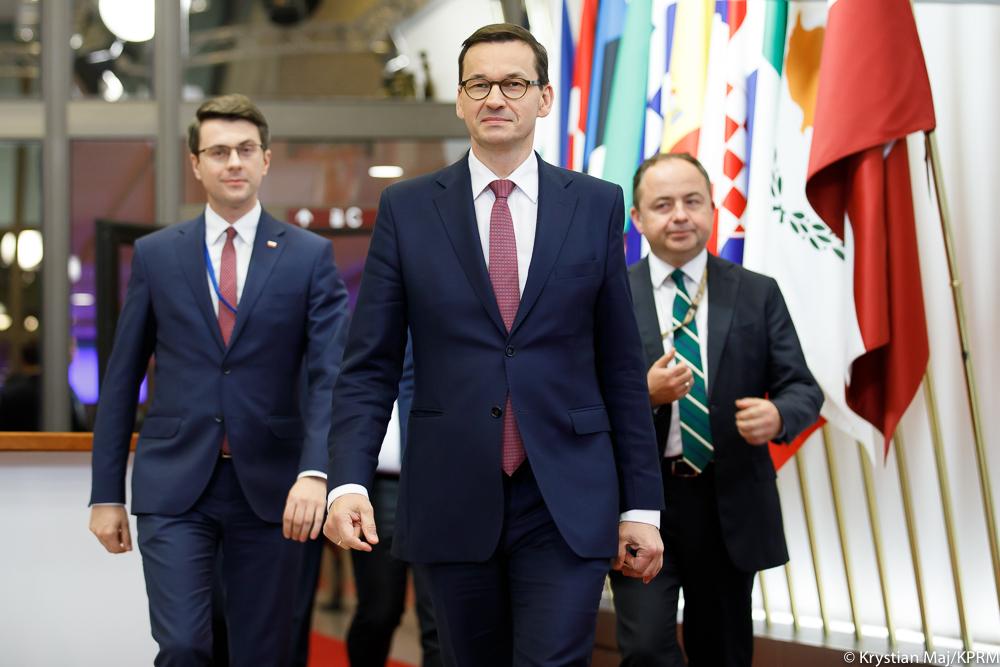Premier Mateusz Morawiecki, minister Piotr Muller, minister Konrad Szymański idą czerwonym dywanem.