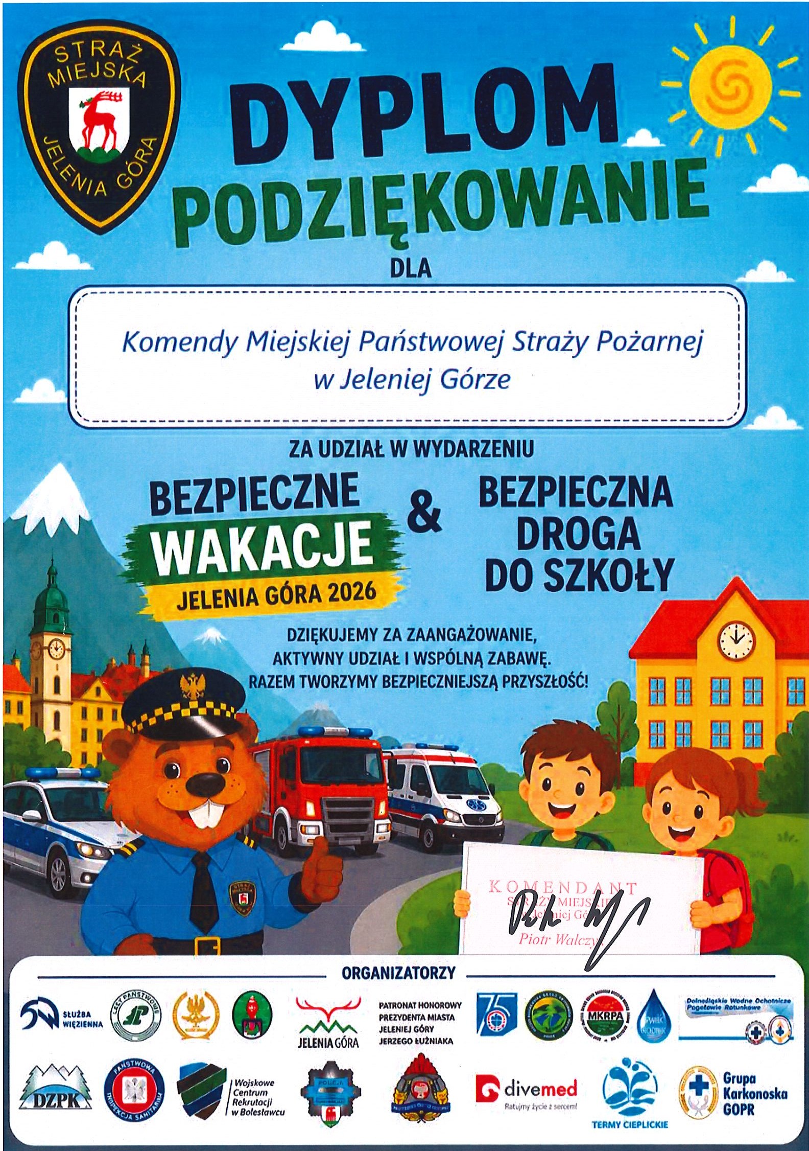 Kolorowy dyplom z podziękowaniem dla Komendy Miejskiej Państwowej Straży Pożarnej w Jeleniej Górze za udział w wydarzeniu „Bezpieczne wakacje & Bezpieczna droga do szkoły – Jelenia Góra 2026”, z ilustracjami służb, dzieci i miejskiego krajobrazu.
