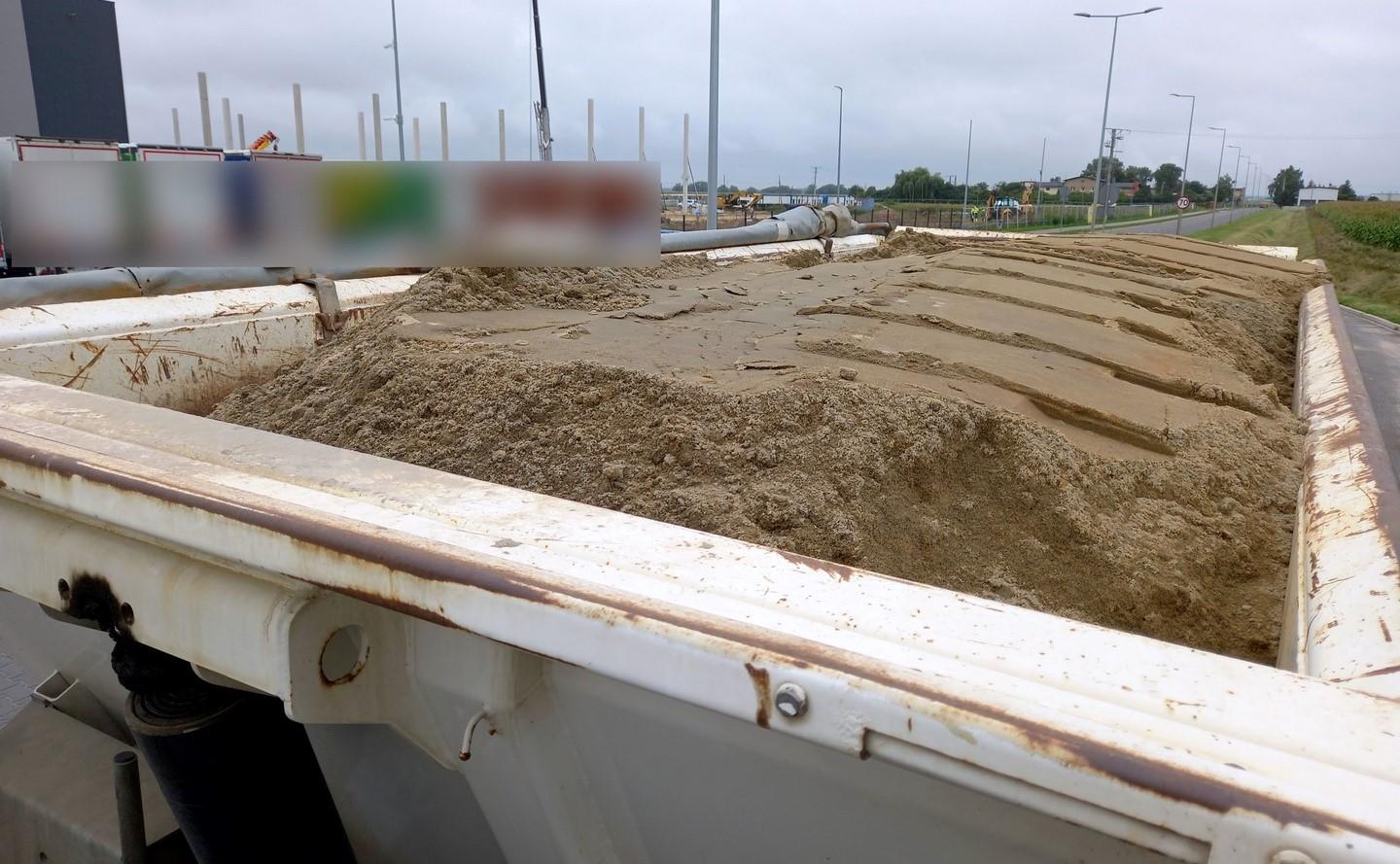 Ładunek piasku niezabezpieczony plandeką.