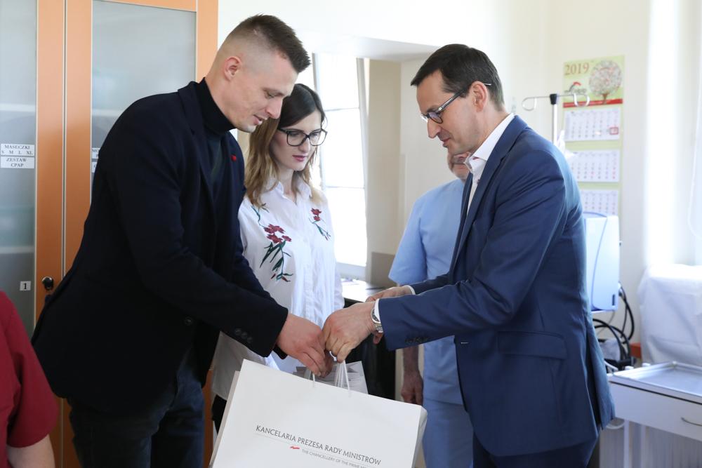 Rodzina Marców, której premier wręcza prezent.