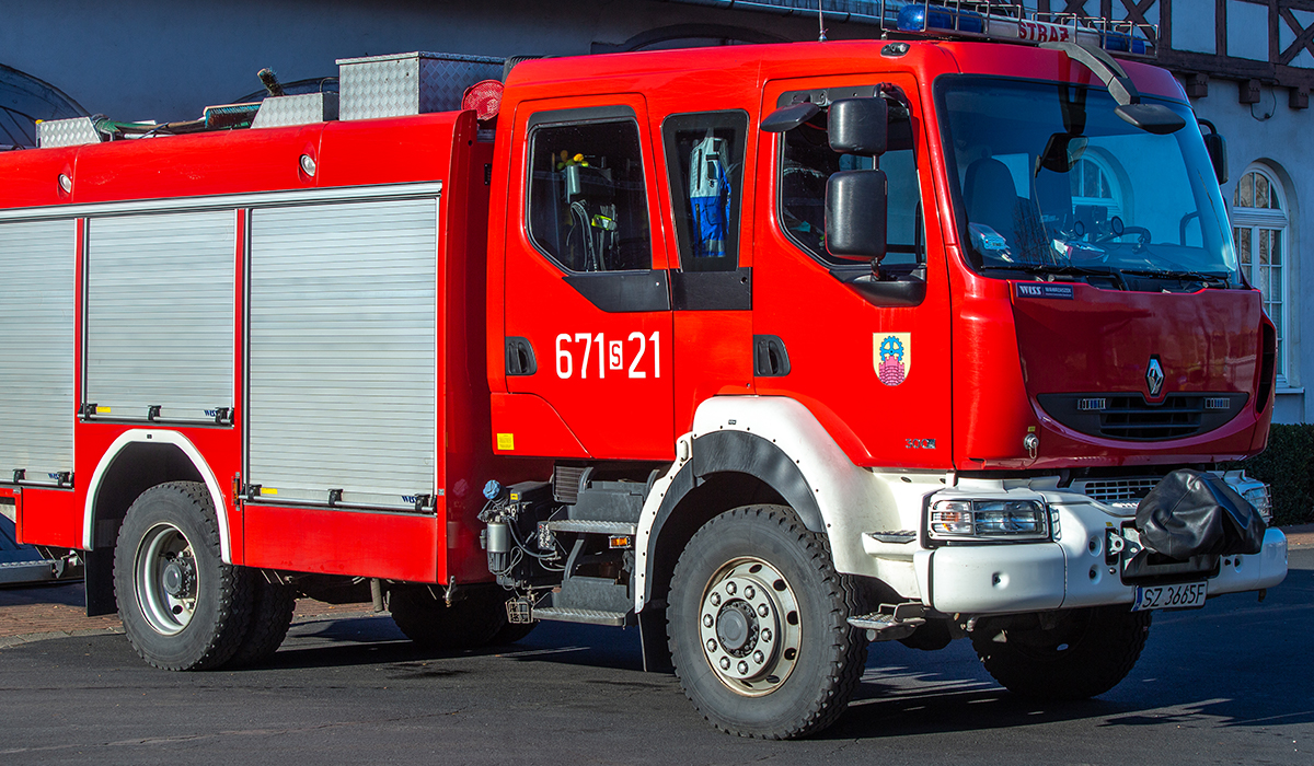 Zdjęcie przedstawia samochód ratowniczo-gaśniczy - średni Renault Midlum na tle budynku Komendy Miejskiej Państwowej Straży Pożarnej w Zabrzu