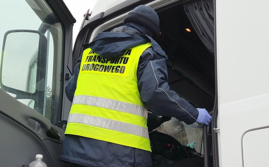 Inspektor kontroluje kierowcę ciężarówki.