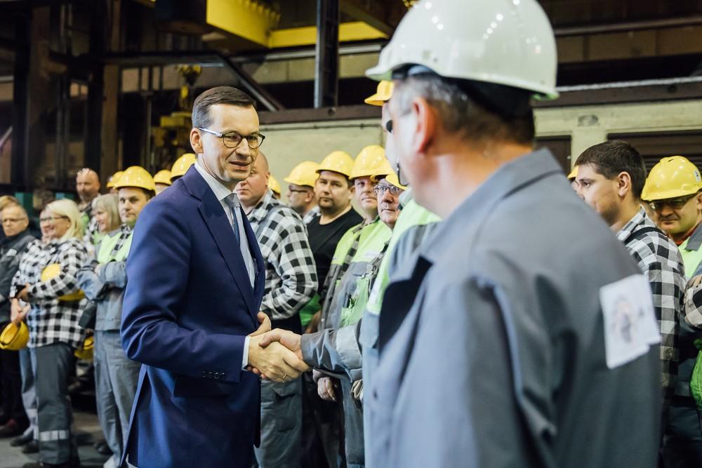 Premier Mateusz Morawiecki wita się z pracownikiem zakładu.