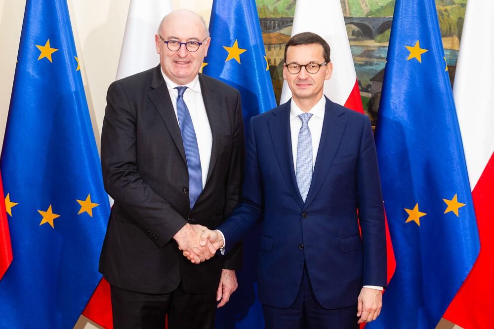 Phil Hogan i Mateusz Morawiecki na tle flag Unii Europejskiej.