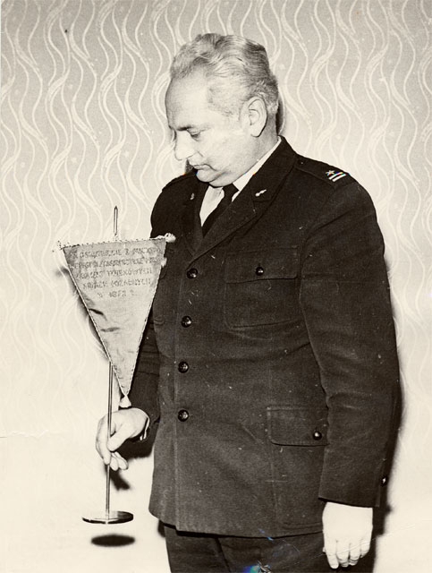 W mundurze bez czapki stoi widoczny do pasa mjr. poż. Józef Strojny – Komendant Wojewódzki Straży Pożarnych w Nowym Sączu, który w ręku trzyma proporczyk.