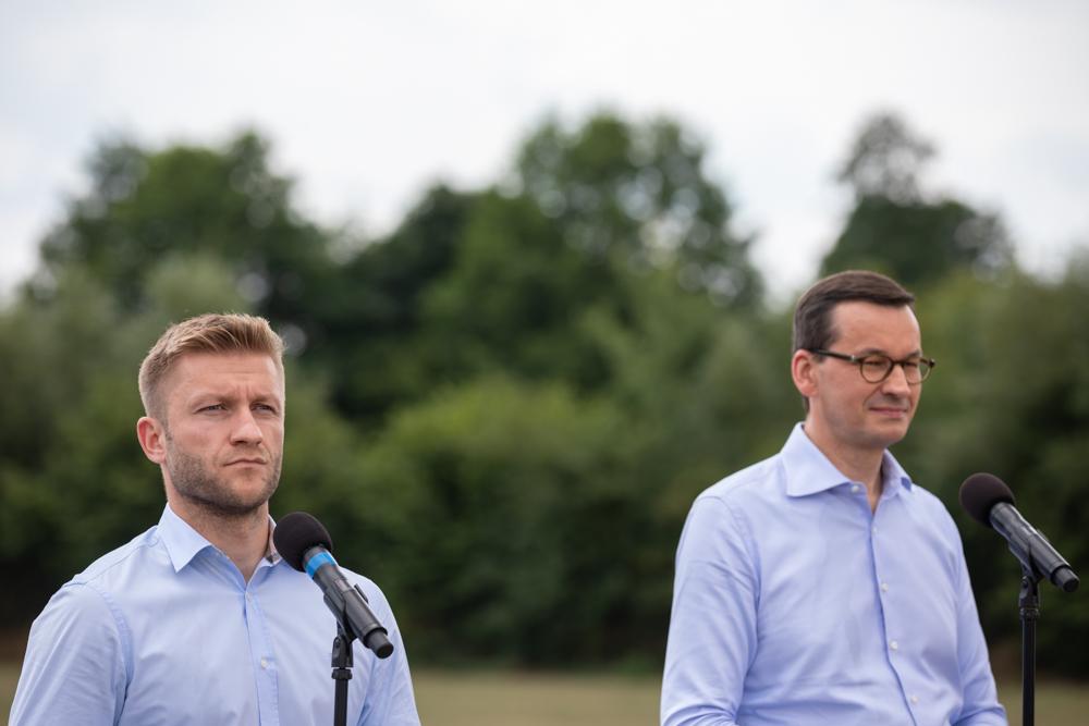 Jakub Błaszczykowski oraz premier Mateusz Morawiecki stoją podczas konferencji.