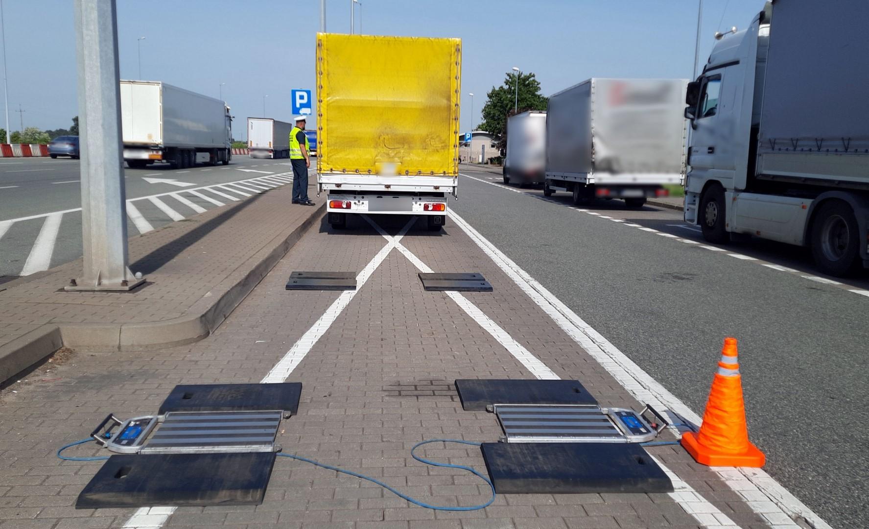 Inspektor stoi przy busie, który zjechał z przenośnych wag ITD.