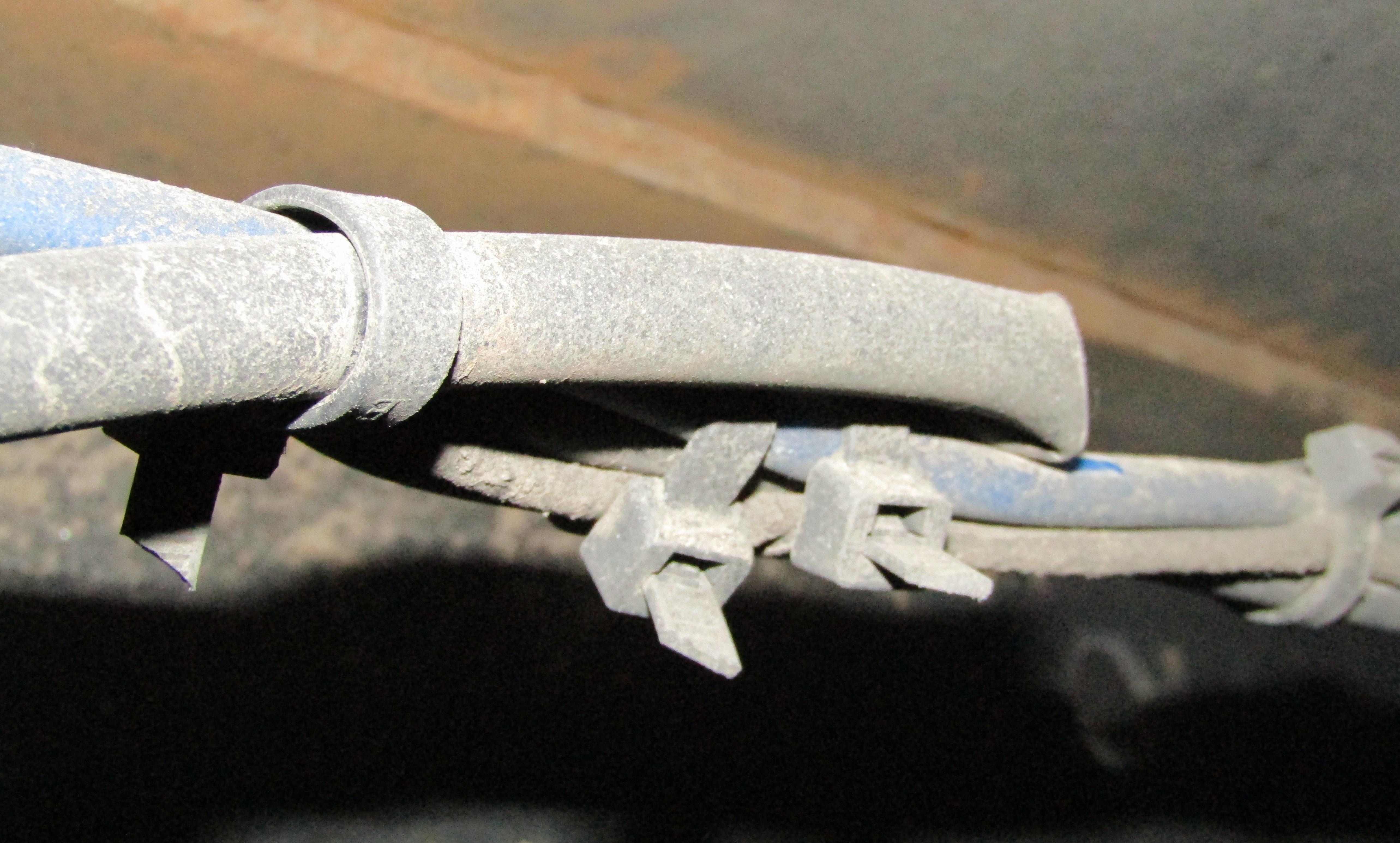 Zaciśnięty plastikową opaską przewód hamulcowy.