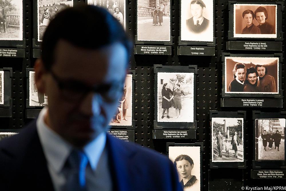 Premier Mateusz Morawiecki w tle zdjęcia.